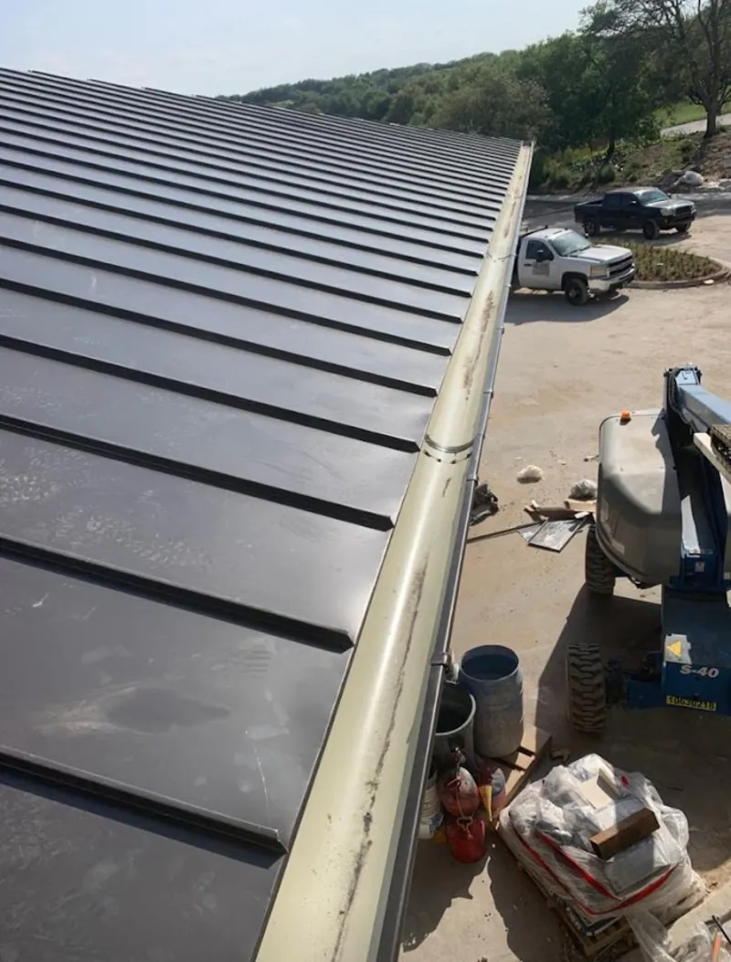 Standing seam panel and gutter detail on a metal roofing jobsite in Elk Plain